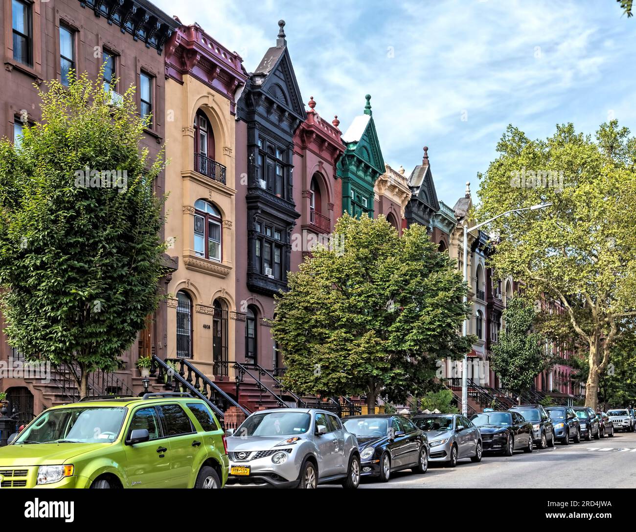 Bedford Stuyvesant: 1899 residenze in pietra marrone su Greene Street con alte scalinate ed elaborate cornici in metallo, dipinte sopra. Foto Stock