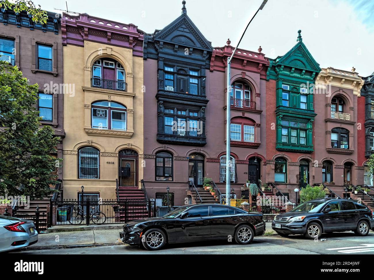 Bedford Stuyvesant: 1899 residenze in pietra marrone su Greene Street con alte scalinate ed elaborate cornici in metallo, dipinte sopra. Foto Stock