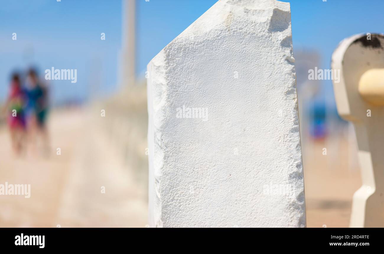 Post informativo in pietra bianca senza iscrizioni. Pilastro di pietra sul molo. La superficie per l'iscrizione. Foto Stock