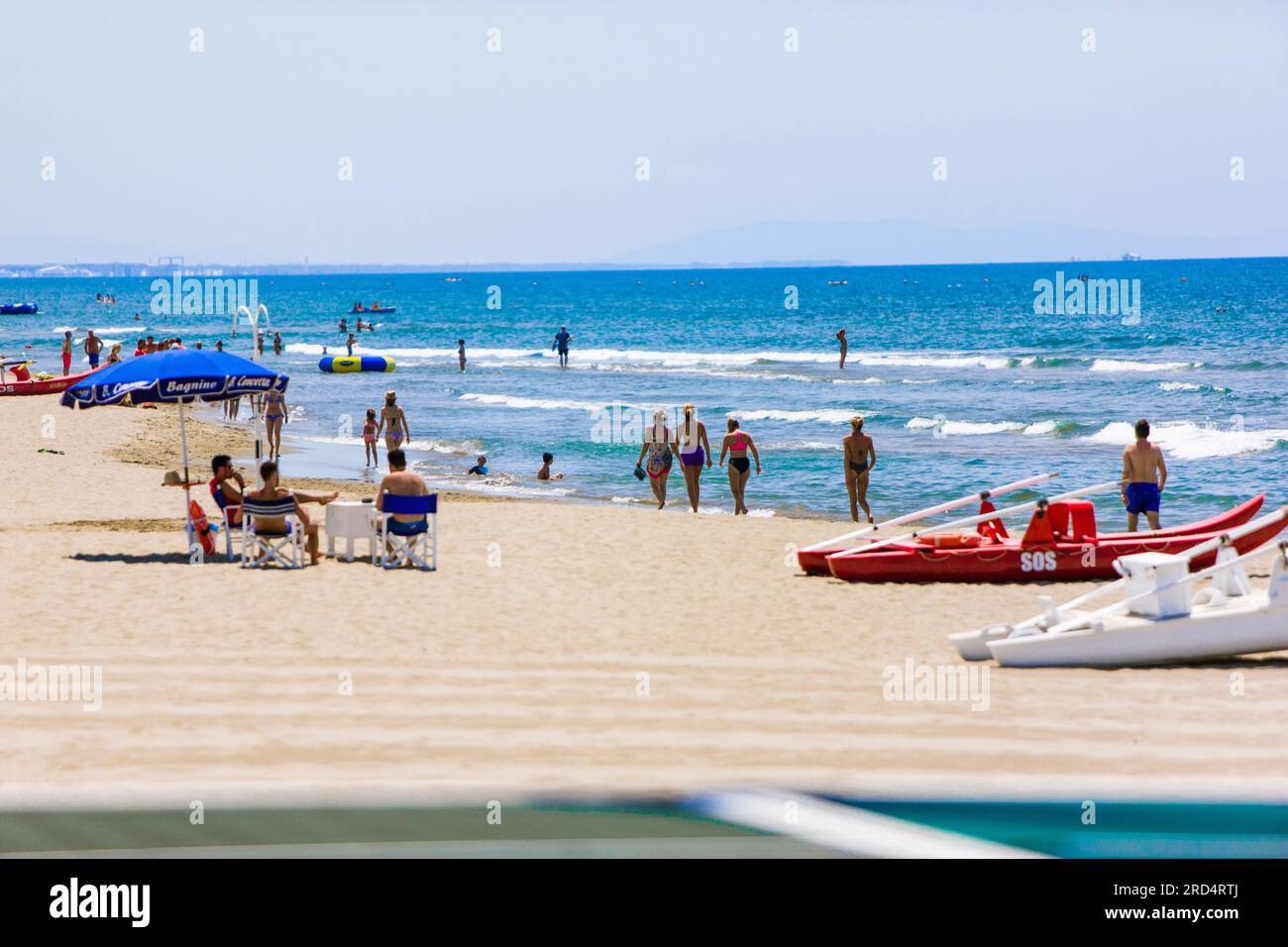 spiaggia in italia, in una giornata di sole. Ombrelloni blu, poche persone e una spiaggia solo per te Foto Stock