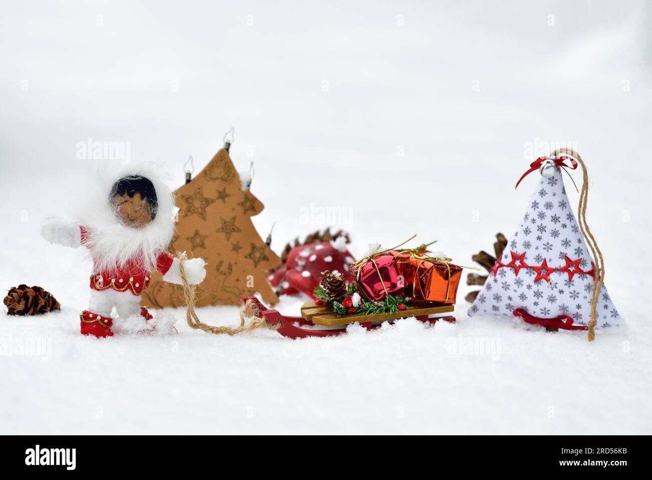 Decorazione natalizia, Inuit che tira la slitta con regali di Natale sulla neve Foto Stock