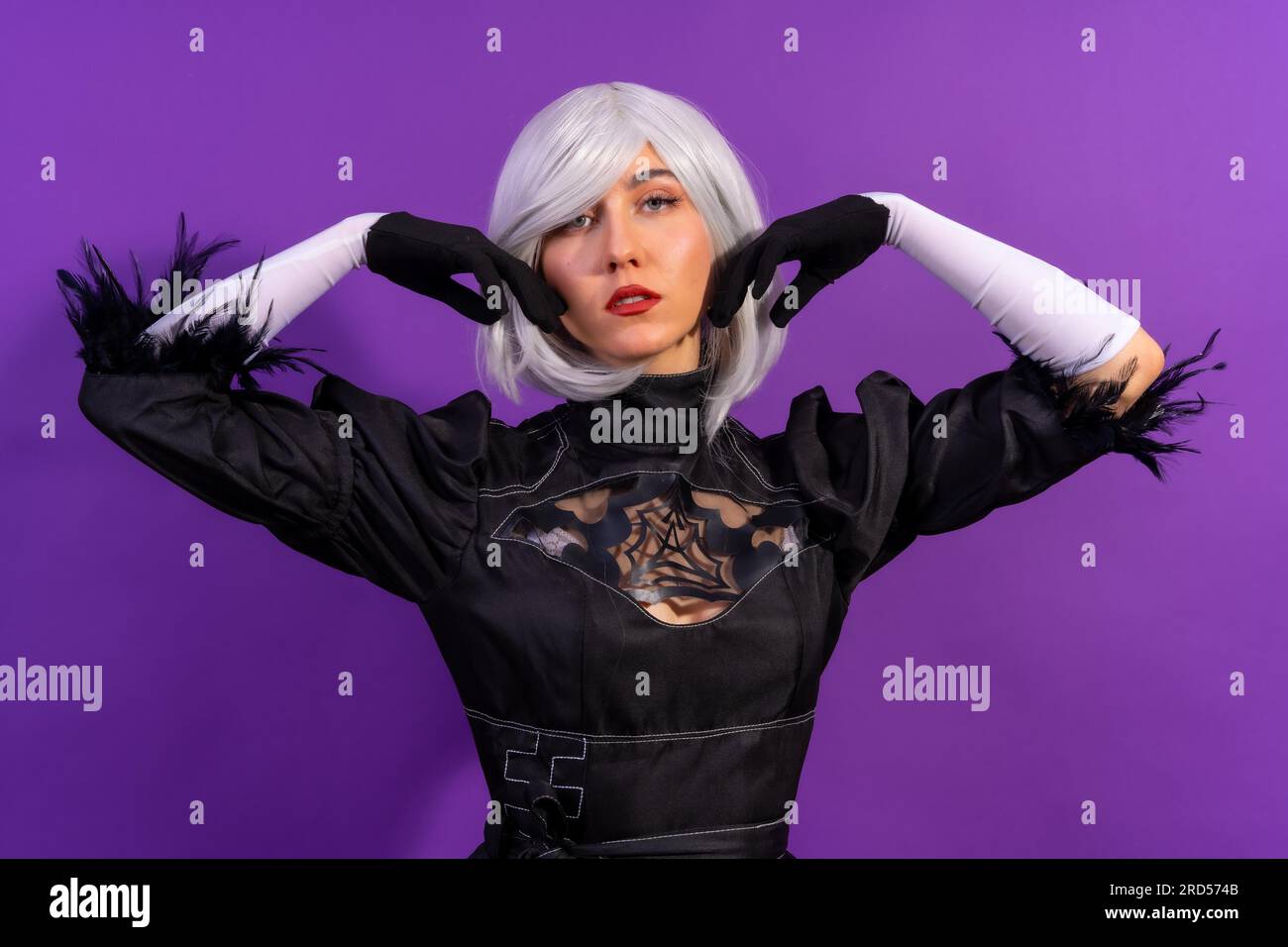 Ritratto di una donna cosplay in costume nero e parrucca bianca in studio  su sfondo viola Foto stock - Alamy