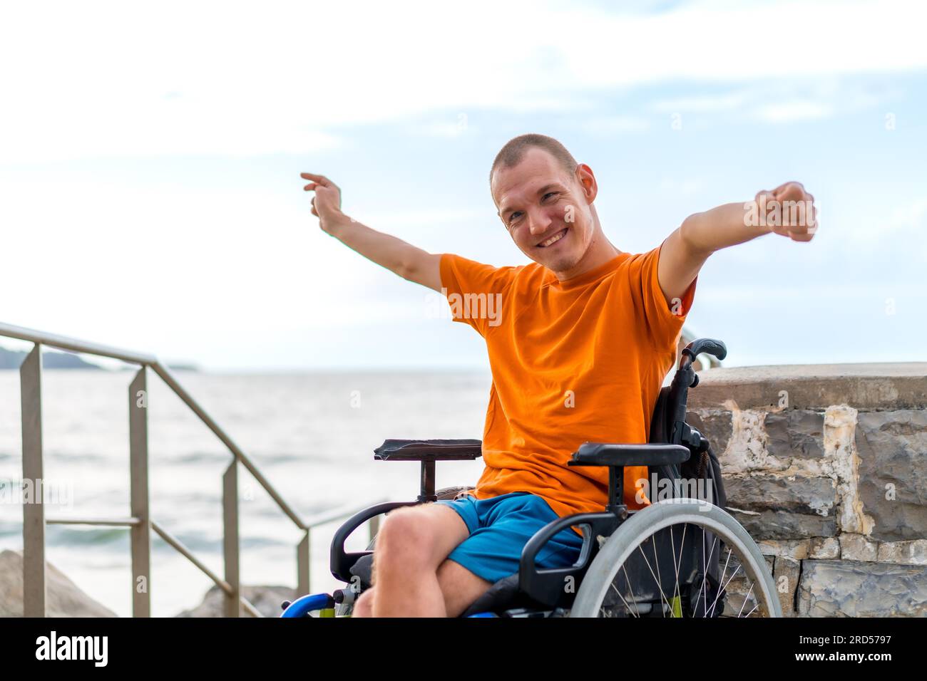 Ritratto di una persona disabile molto allegra in sedia a rotelle in vacanza Foto Stock