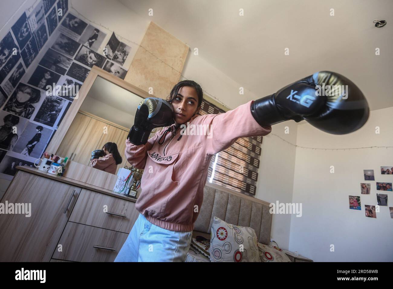 Gaza City, territori palestinesi. 18 luglio 2023. La palestinese Farah Abu al-Qumsan, 16 anni, si prepara all'interno della sua casa per il primo torneo di pugilato femminile, che si terrà presso la sala al-Mashtal Sports Club di Gaza City. Credito: Mohammed Talatene/dpa/Alamy Live News Foto Stock