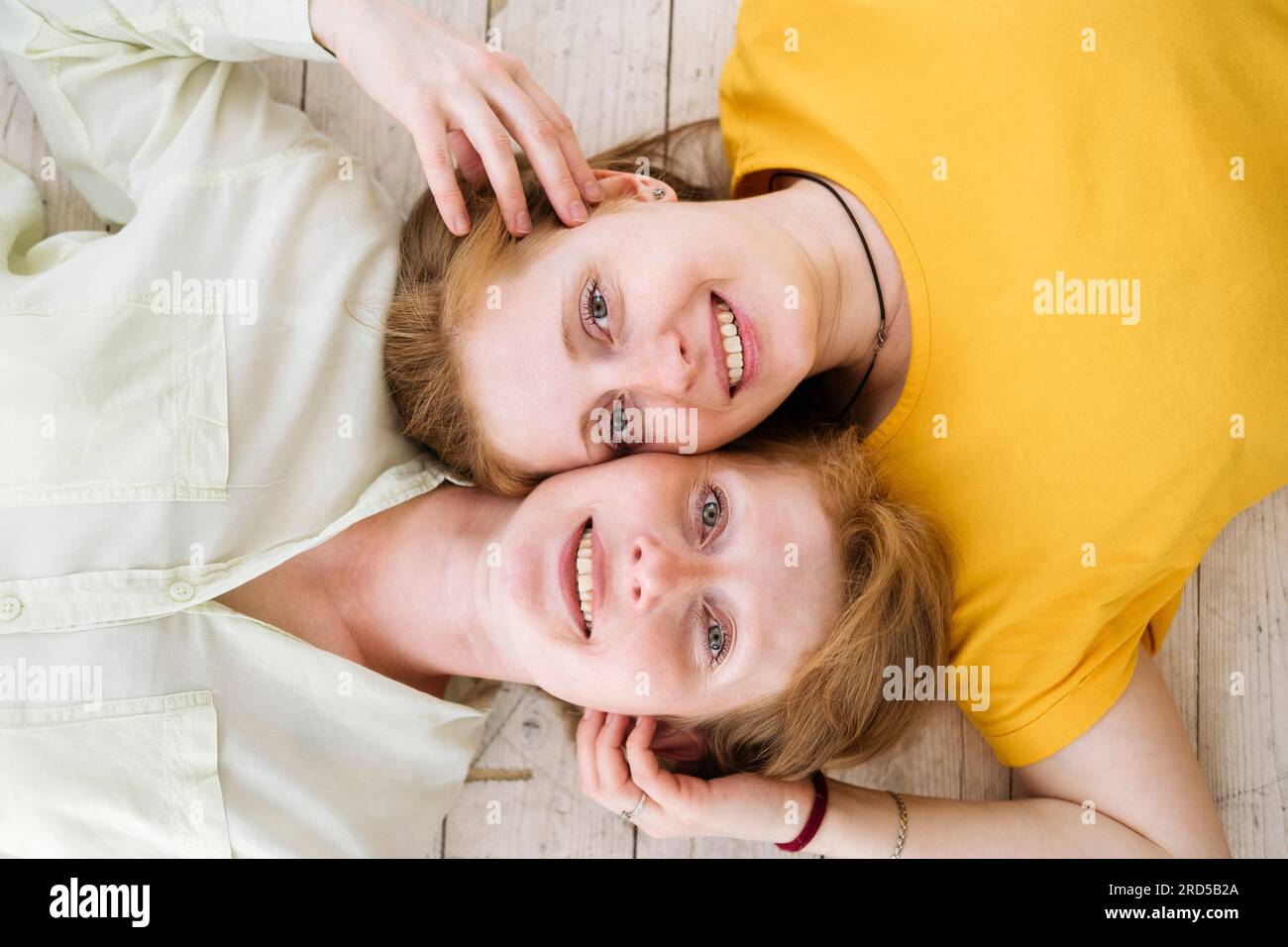 Due sorelle dai capelli rossi giacciono la guancia e sorridono. Donne simili con pelle chiara e lentiggini. Foto Stock