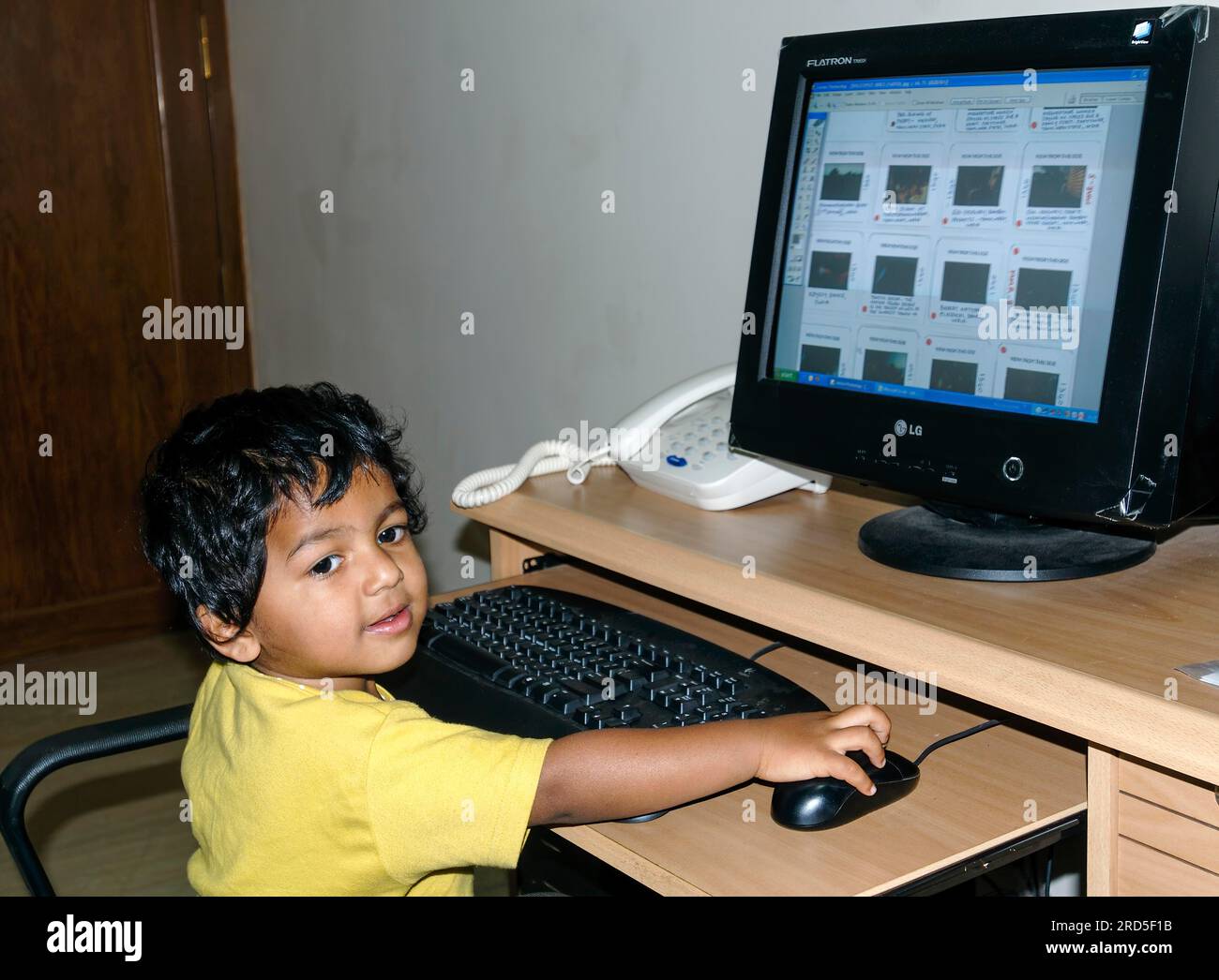 Un bambino del sud dell'India di 2 anni Ashwin che operava un mouse per computer, Karnataka, India meridionale, India, Asia Foto Stock