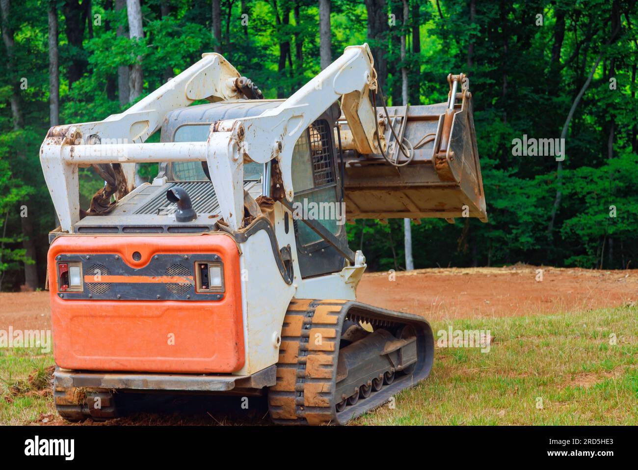 L'utilizzo di mini bulldozer in lavori di architettura paesaggistica comporta un trasferimento preciso del suolo, garantendo una trasformazione del territorio ben realizzata. Foto Stock