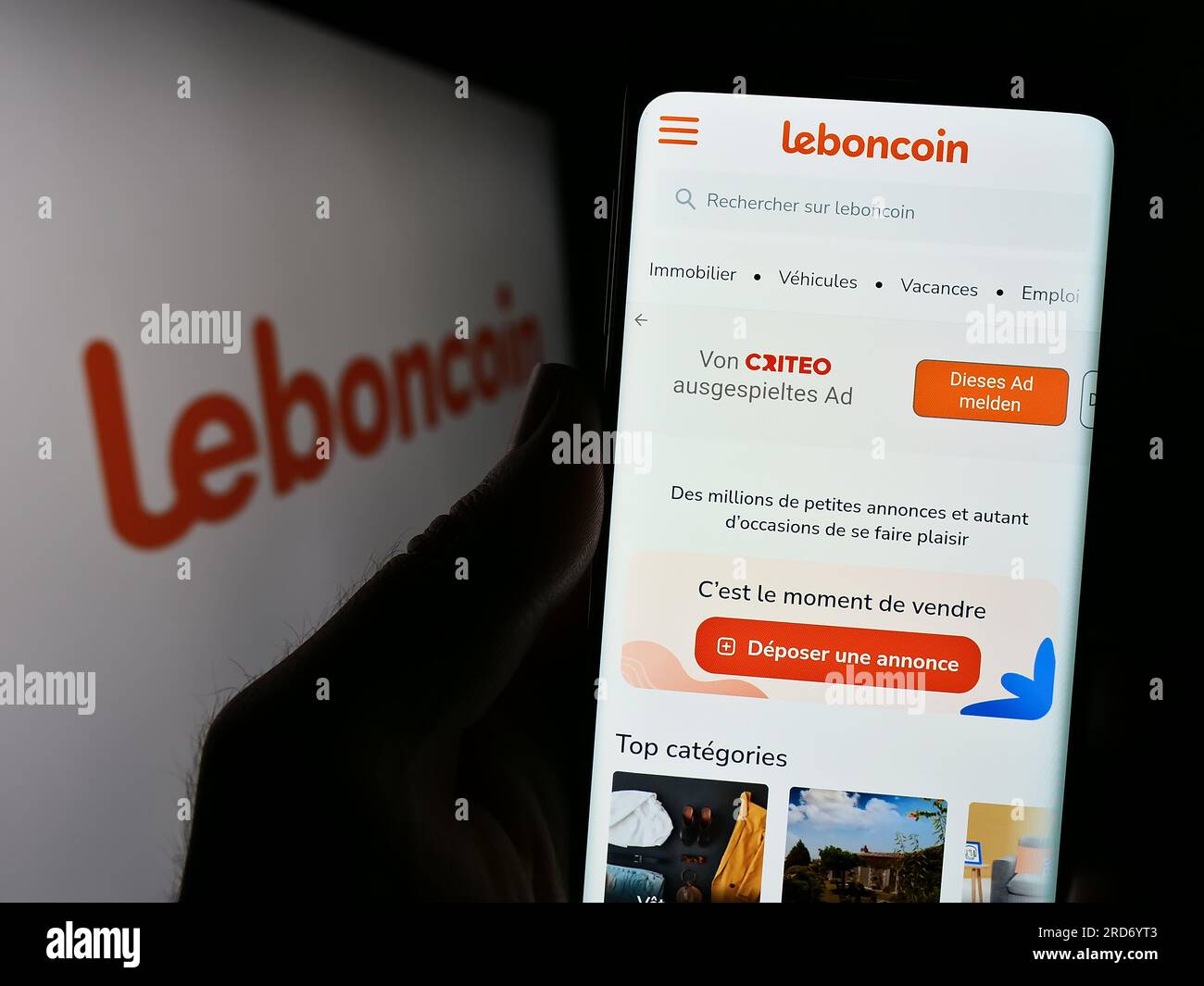 Persona in possesso di cellphoe con una pagina Web dell'azienda francese di annunci classificati Leboncoin sullo schermo davanti al logo. Concentrarsi sul centro del display del telefono. Foto Stock