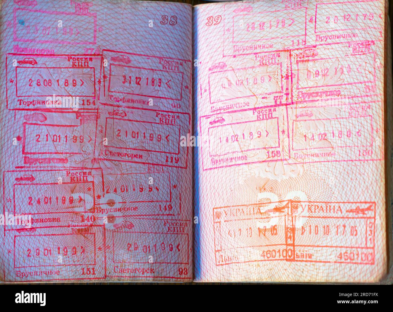 Francobolli di frontiera con i nomi dei punti di frontiera russi e ucraini in un passaporto russo aperto Foto Stock