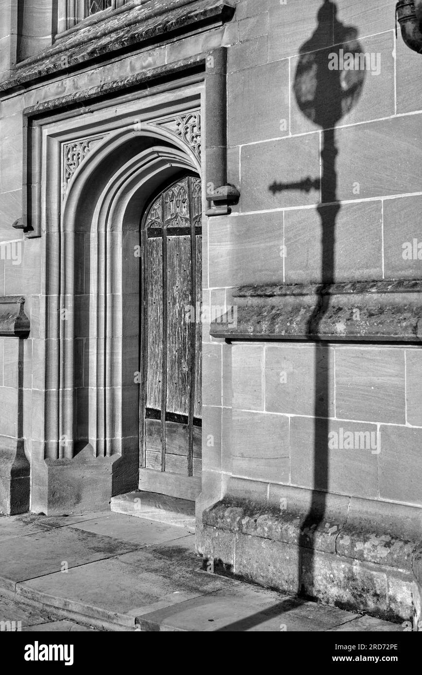 Ombre sul muro. Porta della Guild Chapel e illuminazione stradale Shadow, Church Street, Stratford Upon Avon, Inghilterra Regno Unito. Fotografia in bianco e nero Foto Stock