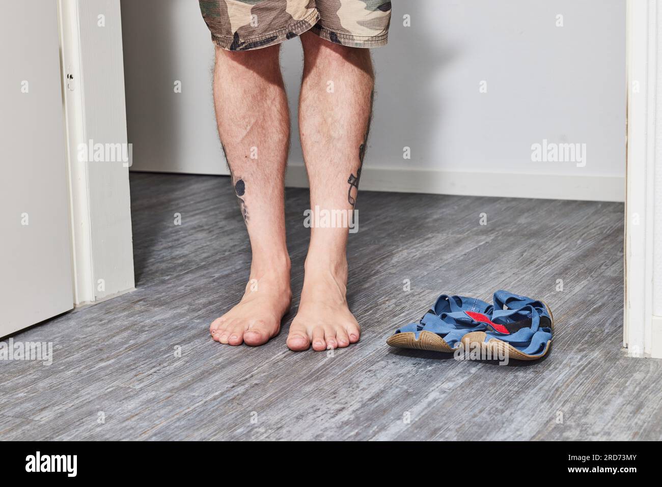 Uomo con scarpe a piedi nudi in piedi sul pavimento Foto Stock