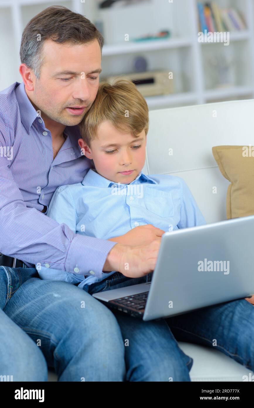 Padre e figlio guardando al laptop Foto Stock