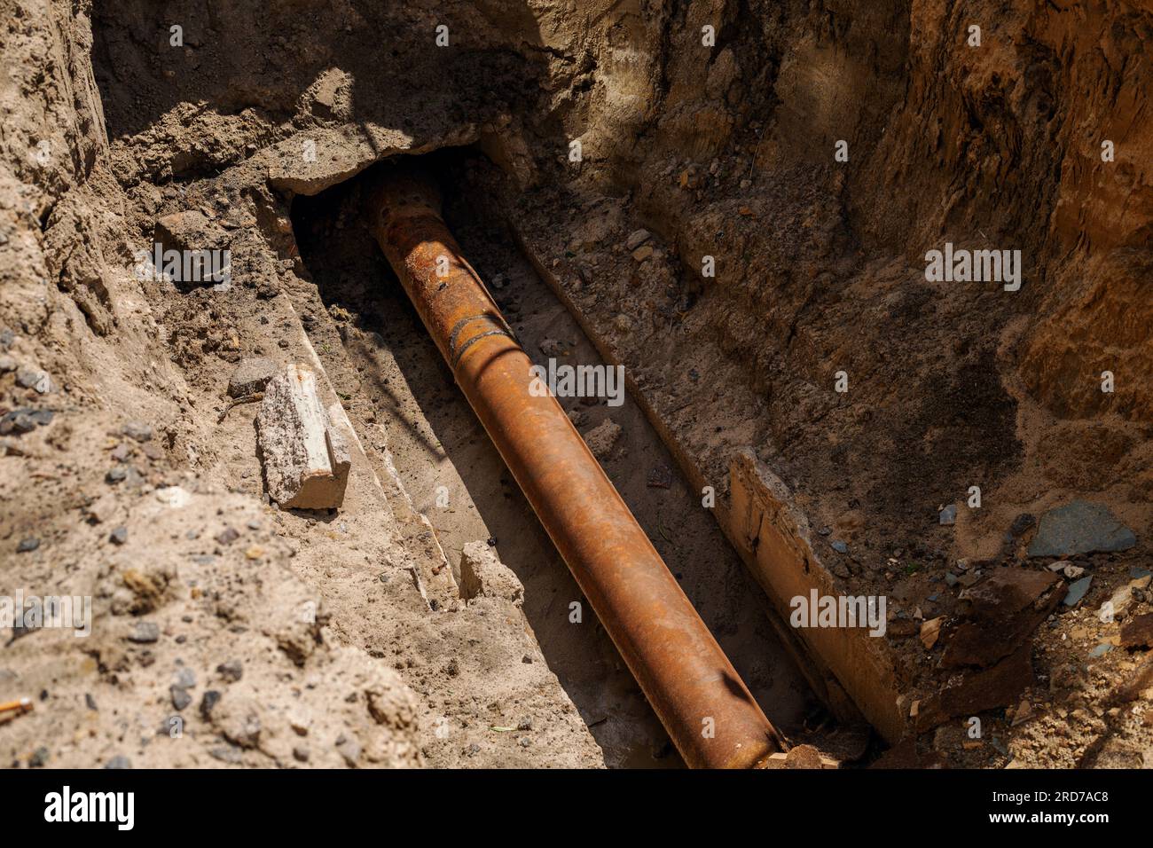 è stato scavato un foro per riparare il tubo e sostituire il maschio. Scavo fognario con tubi Foto Stock