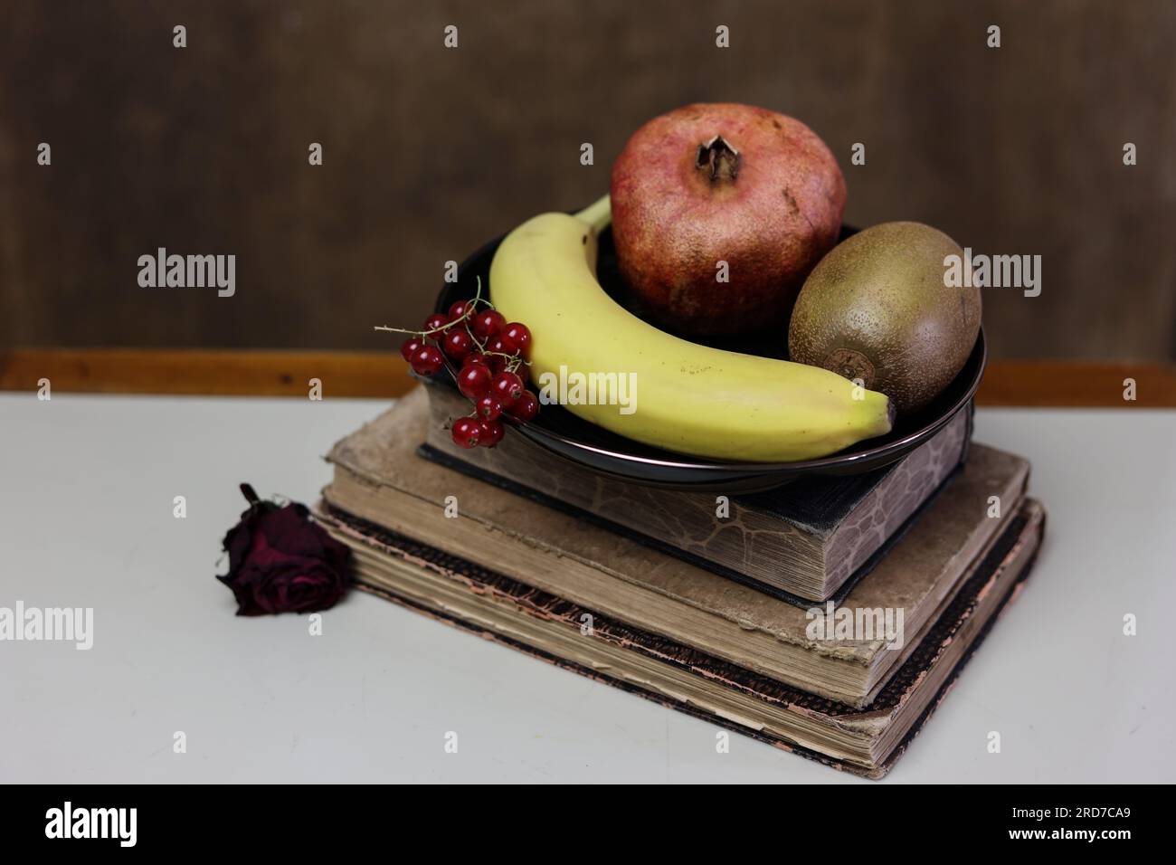 una natura morta con frutta e una pila di libri d'epoca Foto Stock