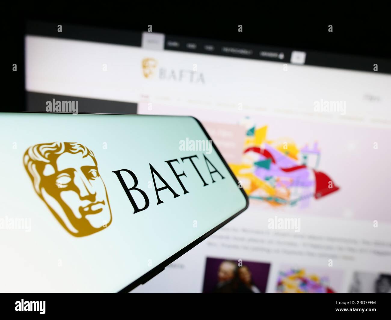 Smartphone con logo dei British Academy Film Awards (BAFTA) sullo schermo davanti al sito Web. Mettere a fuoco il display centrale sinistro del telefono. Foto Stock