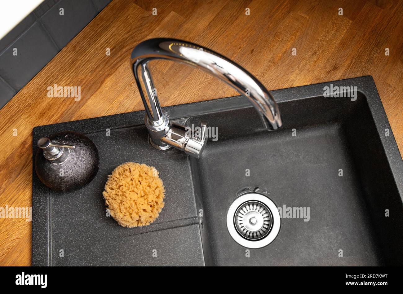 Utilizzo di spugna marina naturale per lavare i piatti in cucina. Spugna marina raccolta biologica sul lavello della cucina accanto al sapone liquido per piatti. Foto Stock