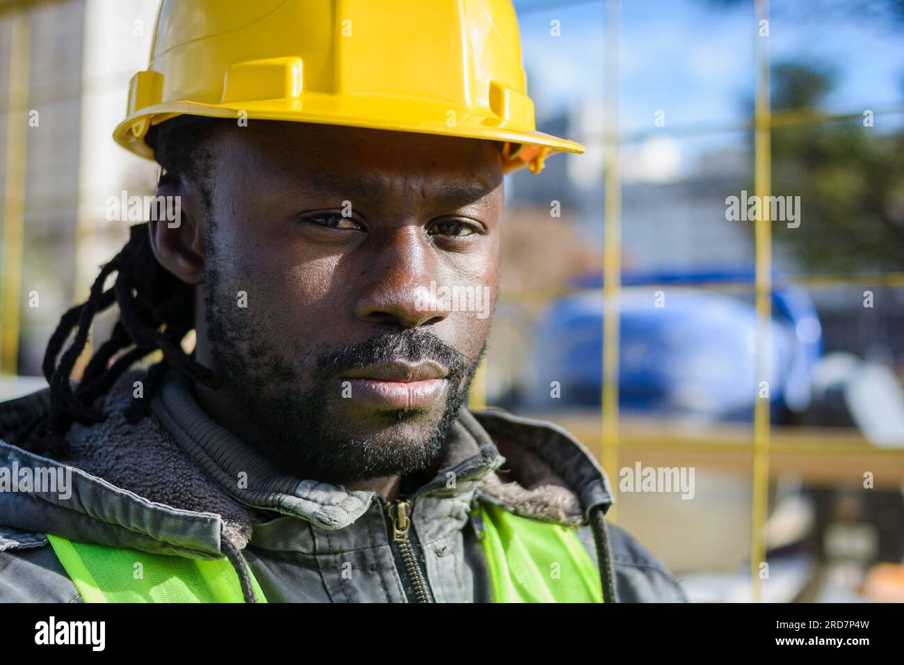 ritratto di un ingegnere barbuto di colore nero, che indossa un supervisore di casco di sicurezza che guarda la fotocamera all'aperto in cantiere, concetto industriale, c Foto Stock