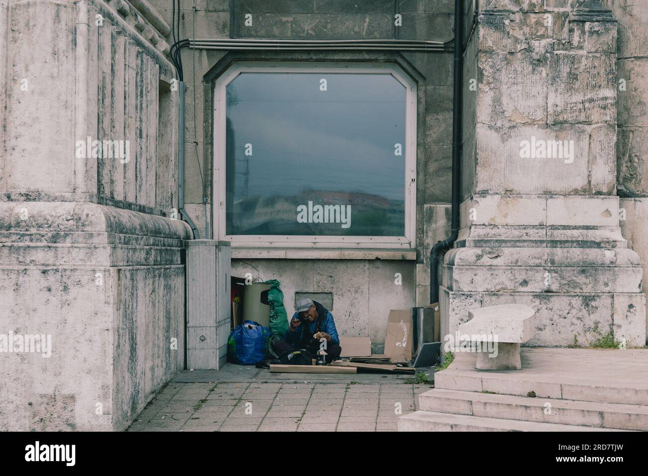 Un senzatetto visto mangiare il suo pranzo, dove di solito dorme anche durante la notte. In Ungheria, soprattutto a Budapest, si è diffusa una preoccupazione per i senzatetto. A causa dell'elevata inflazione, la città ha visto un aumento del numero di persone che vivono nelle strade. Fattori come la povertà, la disoccupazione, problemi di salute mentale e la mancanza di alloggi a prezzi accessibili contribuiscono al problema. Il governo ungherese e le autorità locali hanno attuato varie misure per affrontare i senzatetto. Questi includono la fornitura di rifugi di emergenza, servizi sociali e programmi volti a reintegrare Foto Stock