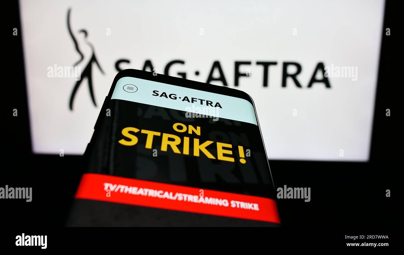 Telefono cellulare con pagina Web del sindacato SAG-AFTRA degli Stati Uniti sullo schermo davanti al logo. Mettere a fuoco in alto a sinistra sul display del telefono. Foto Stock