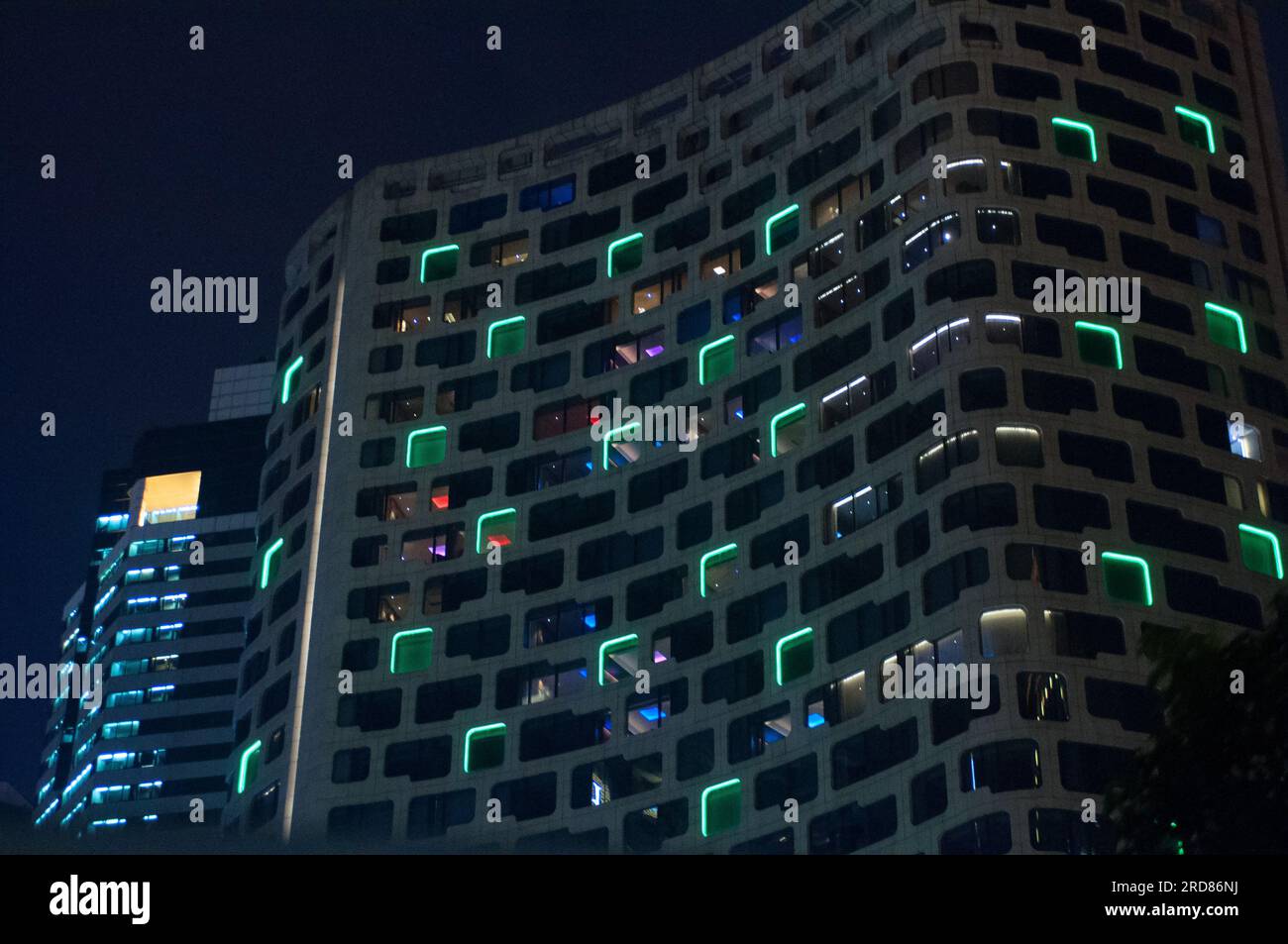 Edificio ondulato con finestre illuminate a LED verde Foto Stock