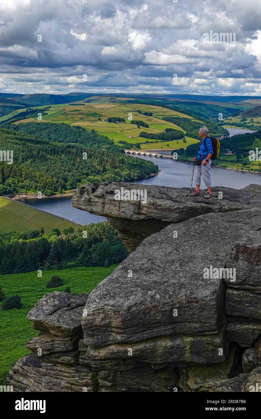Solitaria escursionista femminile nella popolare destinazione di Bamford Edge sopra Ladybower Reservoir, Derbyshire, The Peak District, Regno Unito Foto Stock
