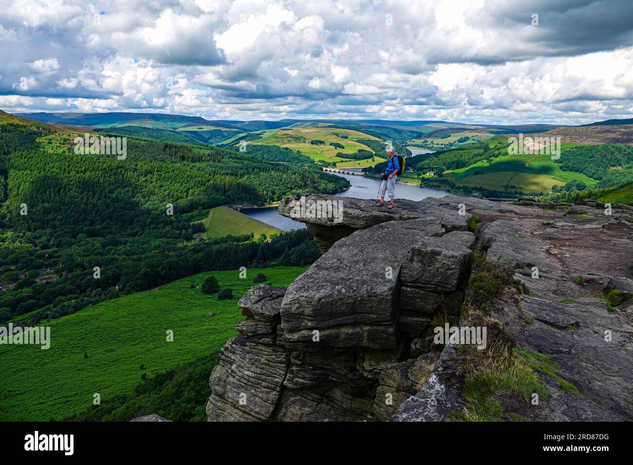 Solitaria escursionista femminile nella popolare destinazione di Bamford Edge sopra Ladybower Reservoir, Derbyshire, The Peak District, Regno Unito Foto Stock