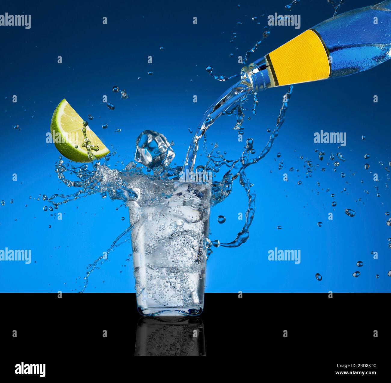 Vetro tonico e lime. Spruzzare acqua tonica in un bicchiere. Foto Stock