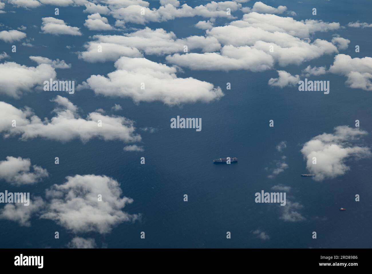 Parigi, Île-de-France, Francia - 30 settembre 2022: Nave cargo lontana sull'Oceano Atlantico tra una moltitudine di White Cumulus Clouds Foto Stock