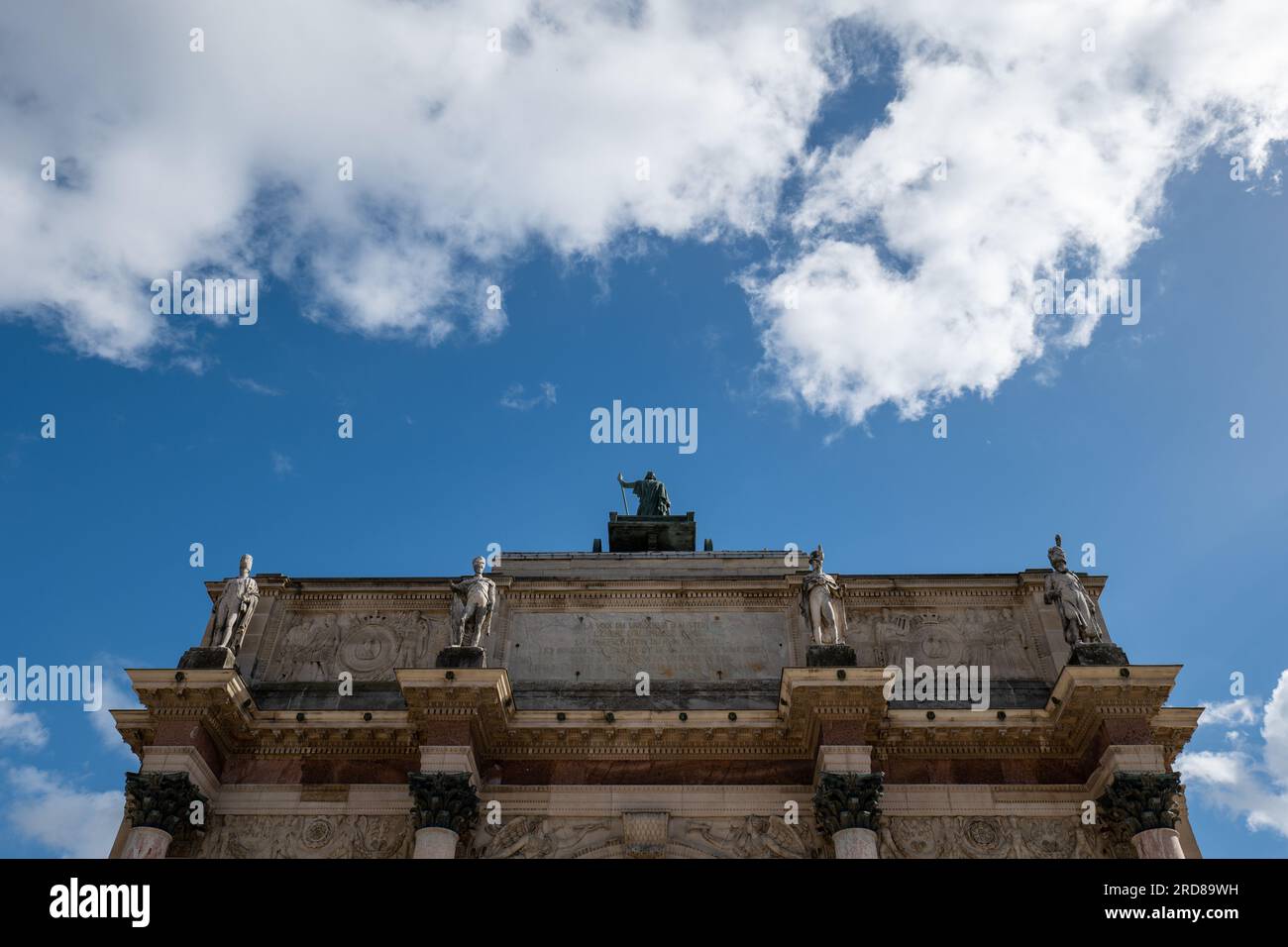 L'Arc de Triomphe du Carrousel con statue nella parte superiore contro il cielo nuvoloso blu Foto Stock