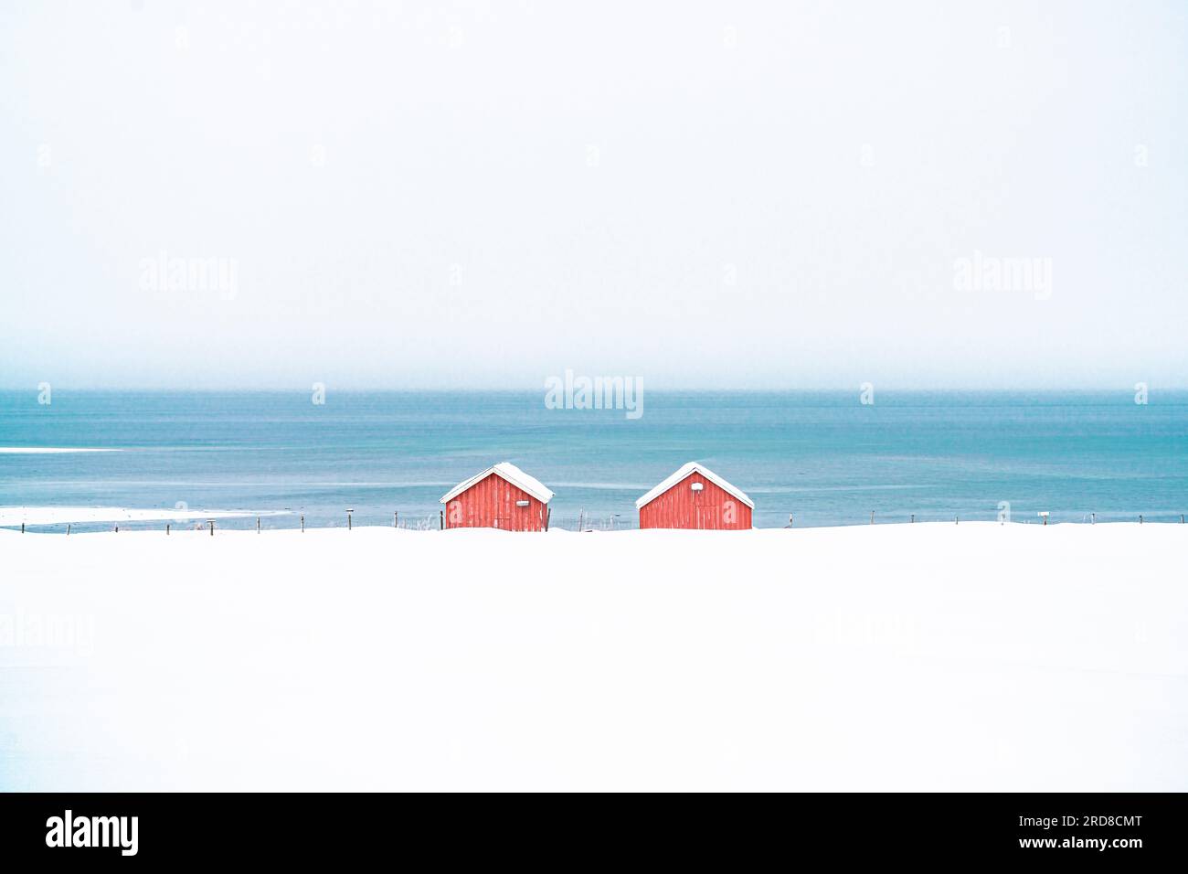 Cabine rosse sulla neve affacciate sul mare ghiacciato, contea di Troms, Norvegia, Scandinavia, Europa Foto Stock