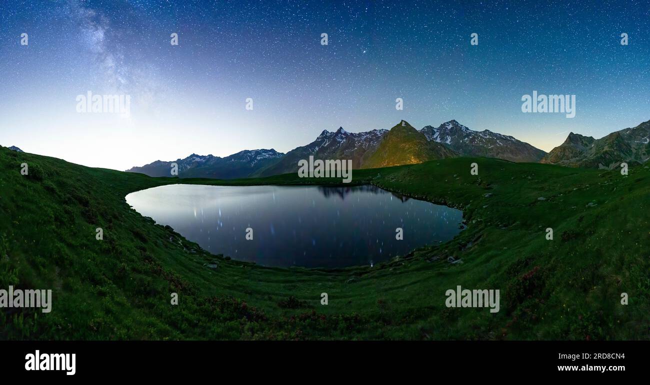 Lago di Andossi illuminato da stelle splendenti nel cielo notturno, Madesimo, Valle Spluga, Valtellina, Lombardia, Italia, Europa Foto Stock