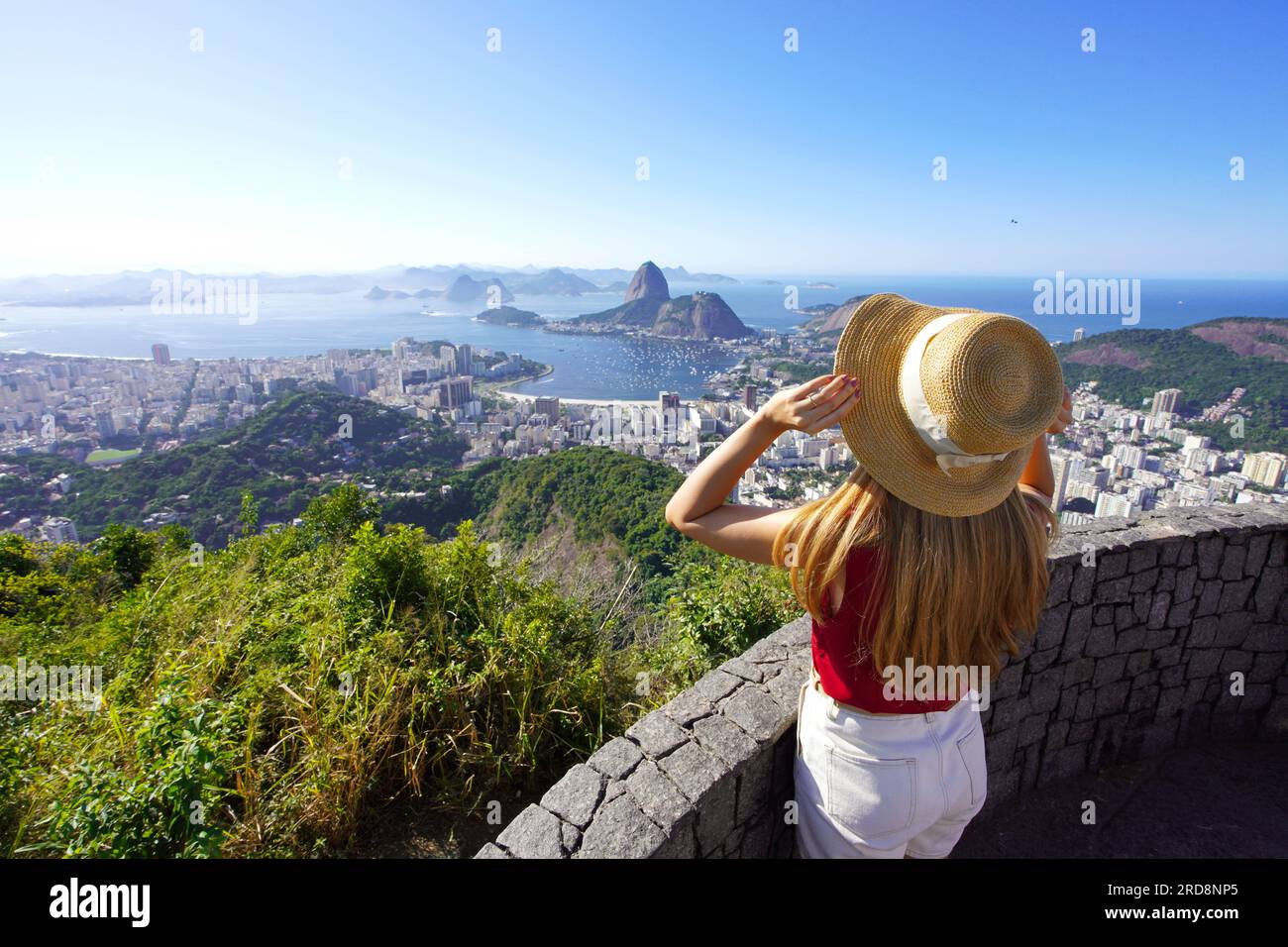 Vista aerea di una ragazza elegante che tiene il cappello sul punto panoramico di Rio de Janeiro con la Baia di Guanabara, Rio de Janeiro, Brasile Foto Stock