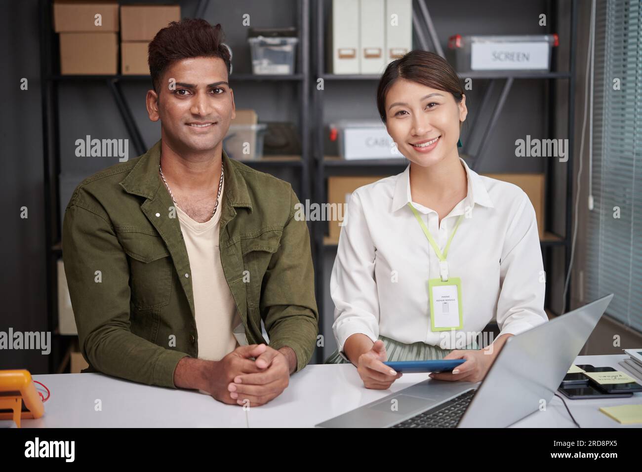 Ritratto del responsabile del servizio di riparazione smartphone e del suo cliente Foto Stock