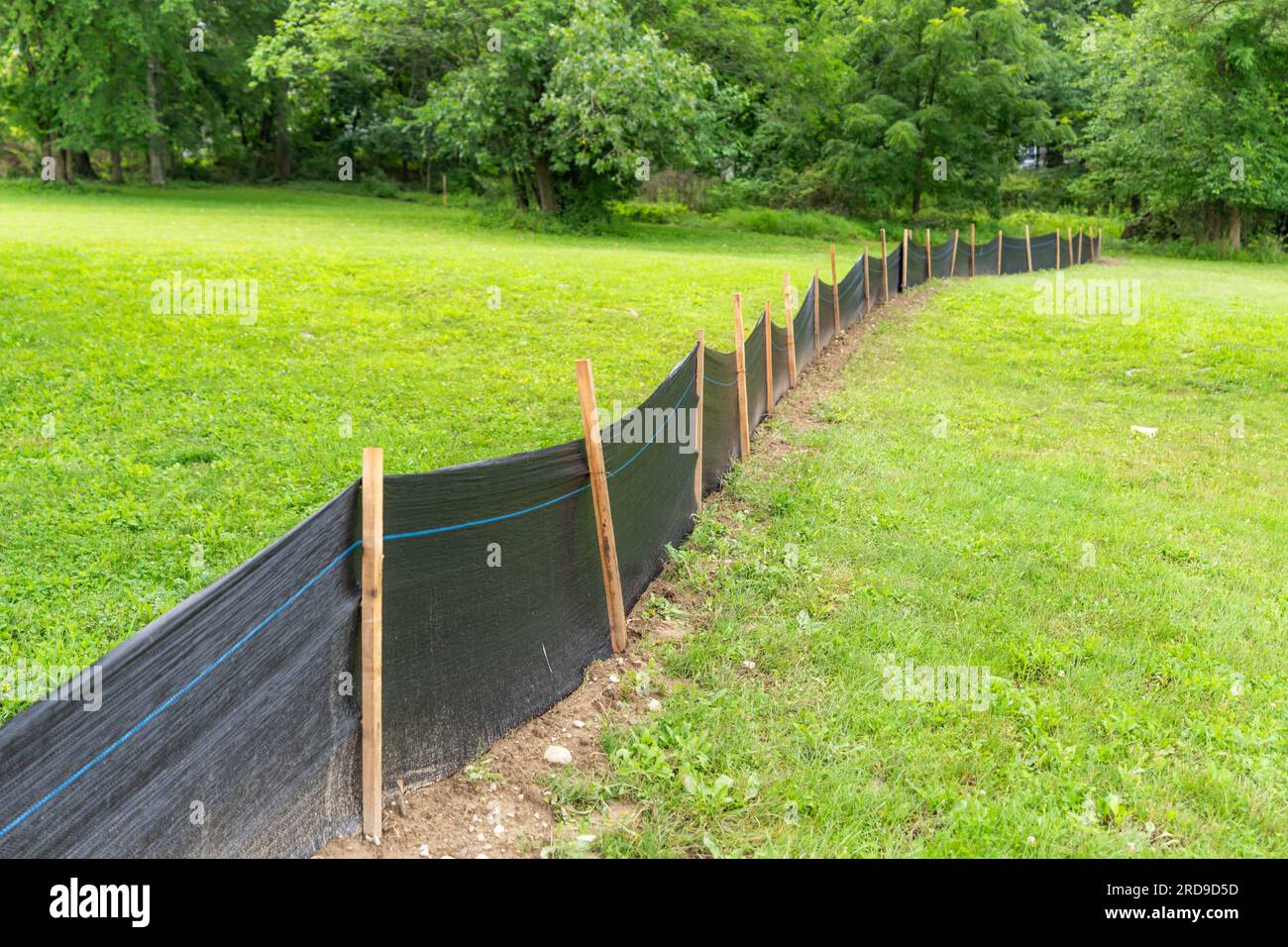 Tessuto Silt Fence con pali in legno installati prima dell'inizio della costruzione. Foto Stock