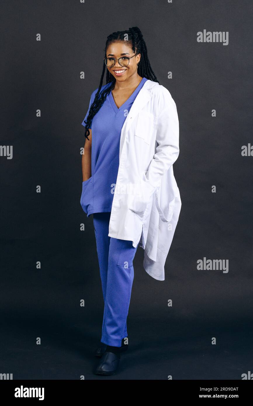Giovane donna sorridente medico o infermiera in cappotto bianco Foto Stock
