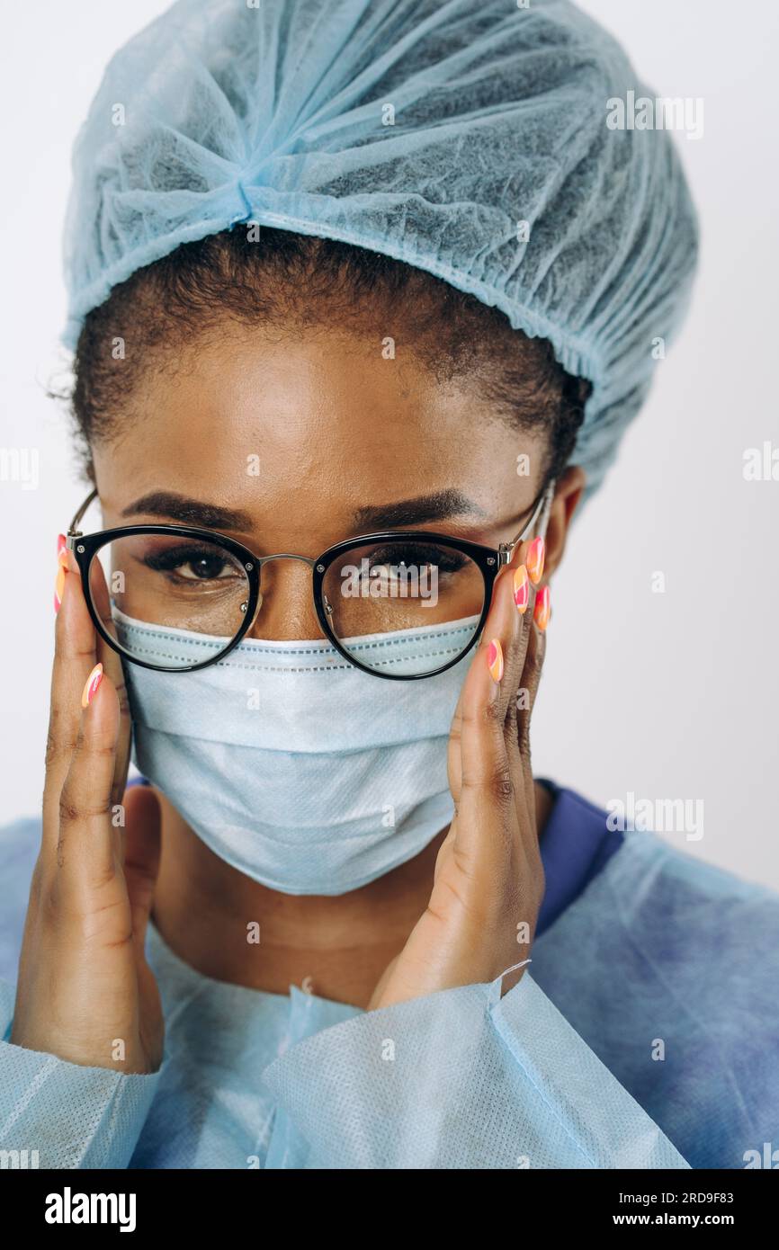 Ritratto di giovane donna afroamericana medico o infermiera donna su abbigliamento protettivo medico con maschera Foto Stock