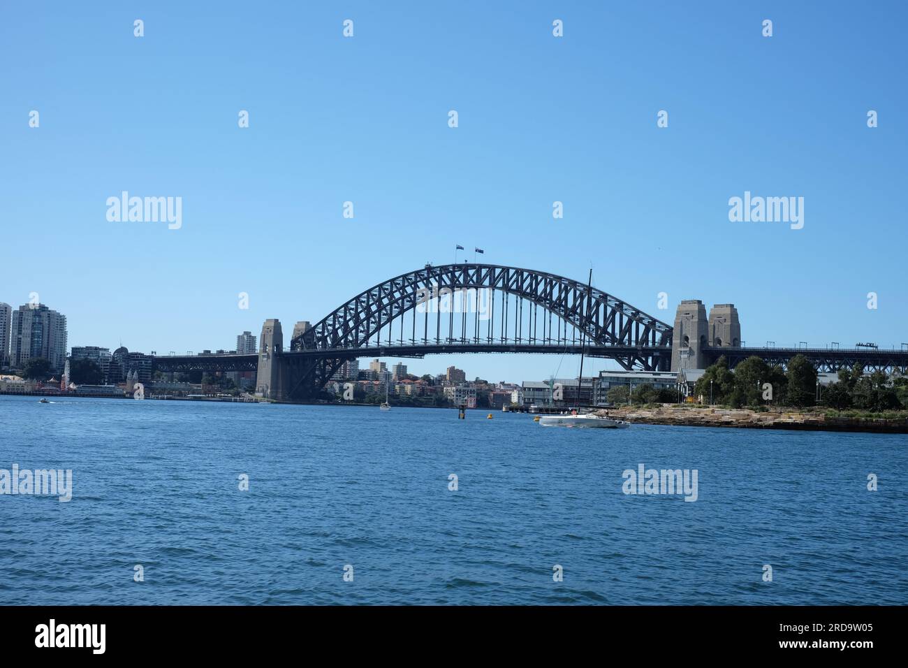 Il Sydney Harbour Bridge è visibile dall'acqua a ovest di Barangaroo, dal cielo azzurro e dalle splendide acque blu Foto Stock
