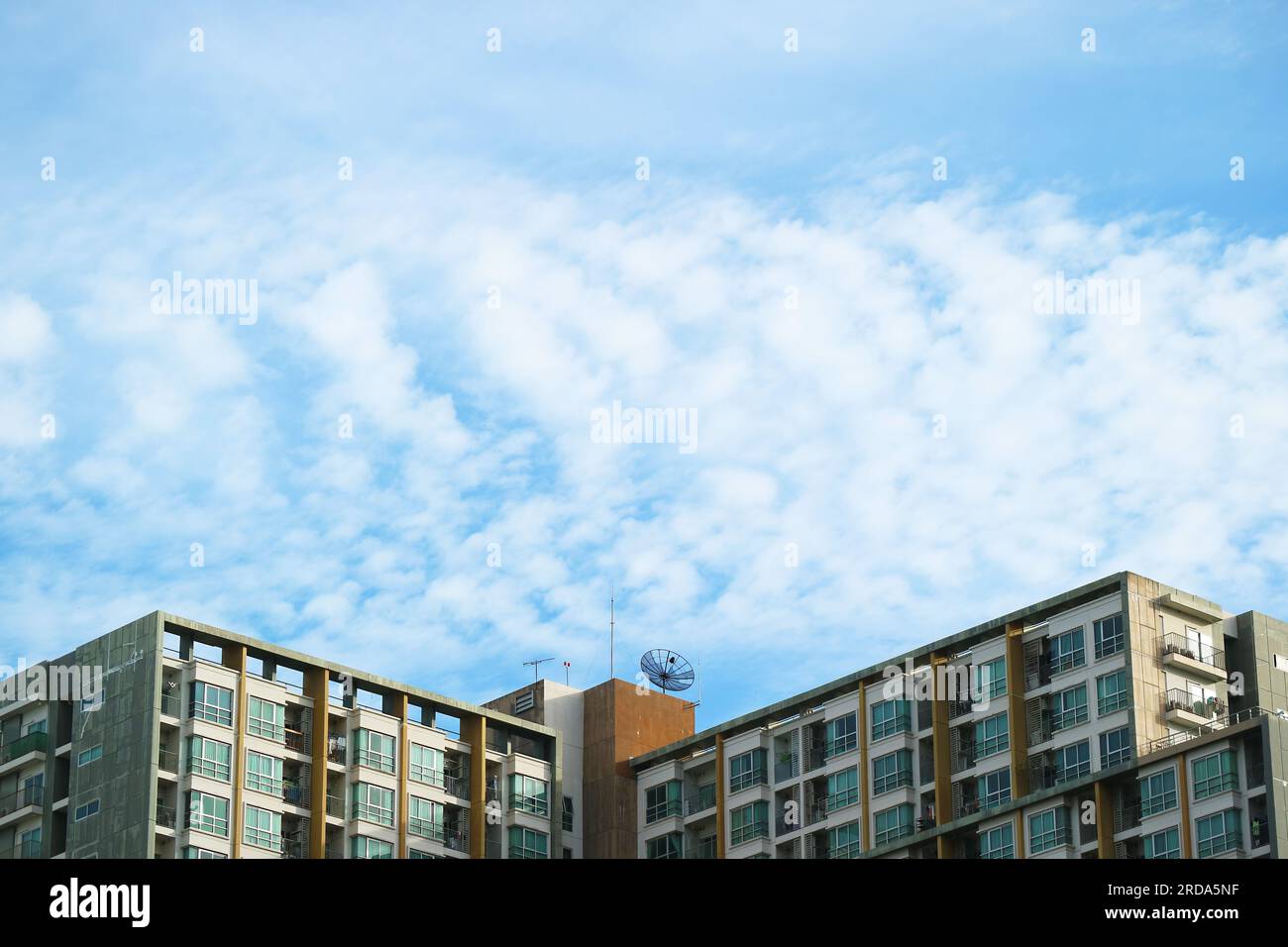 Bellissime nuvole che si diffondono su Light Blue Sky sopra i grattacieli Foto Stock