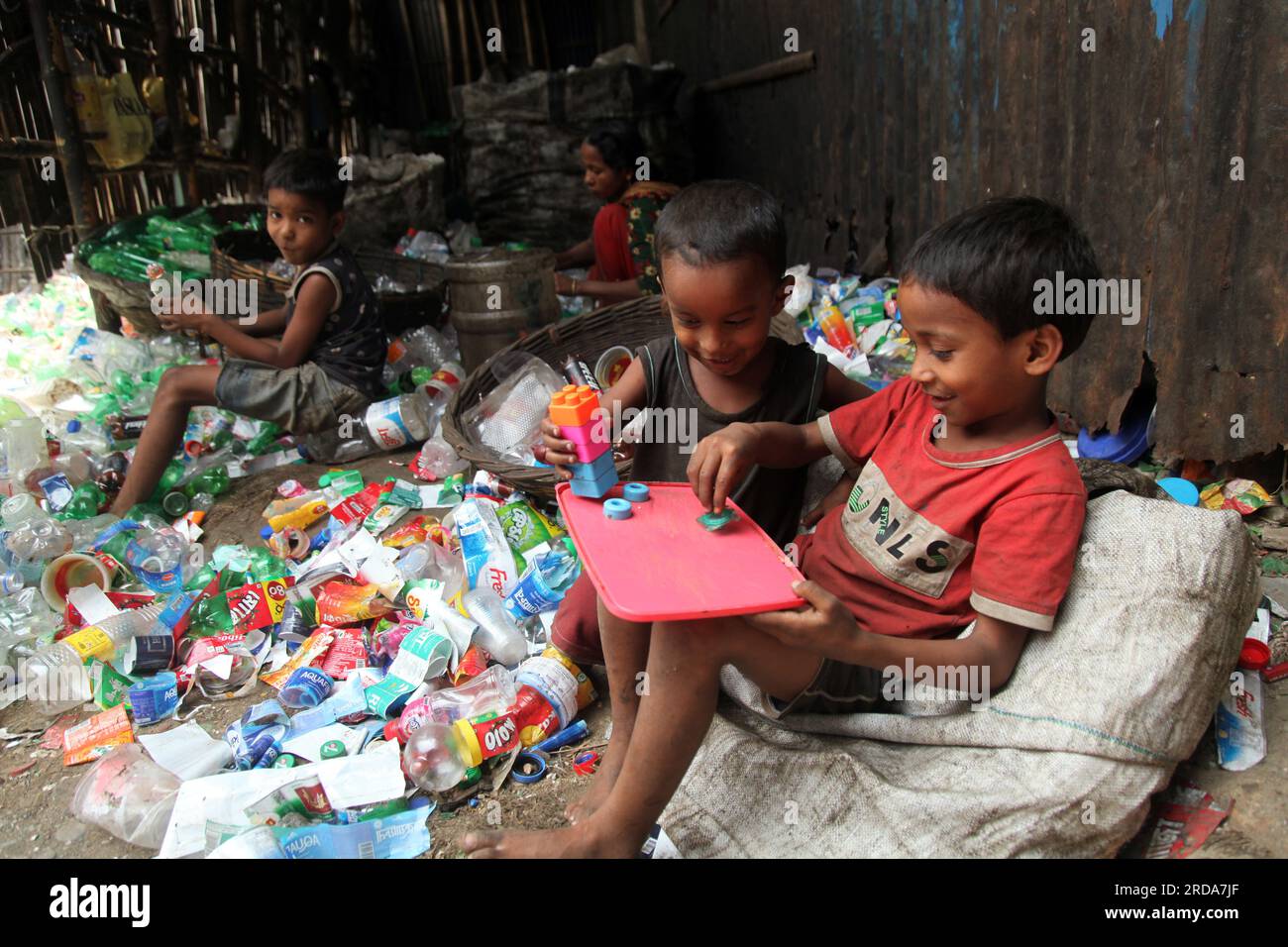 Dhaka, Dhaka, Bangladesh. 18 marzo 2023. I bambini giocano in una fabbrica di riciclaggio di bottiglie di plastica. è stata scattata una foto di kmarangichar beribadgh. Nazmul i Foto Stock