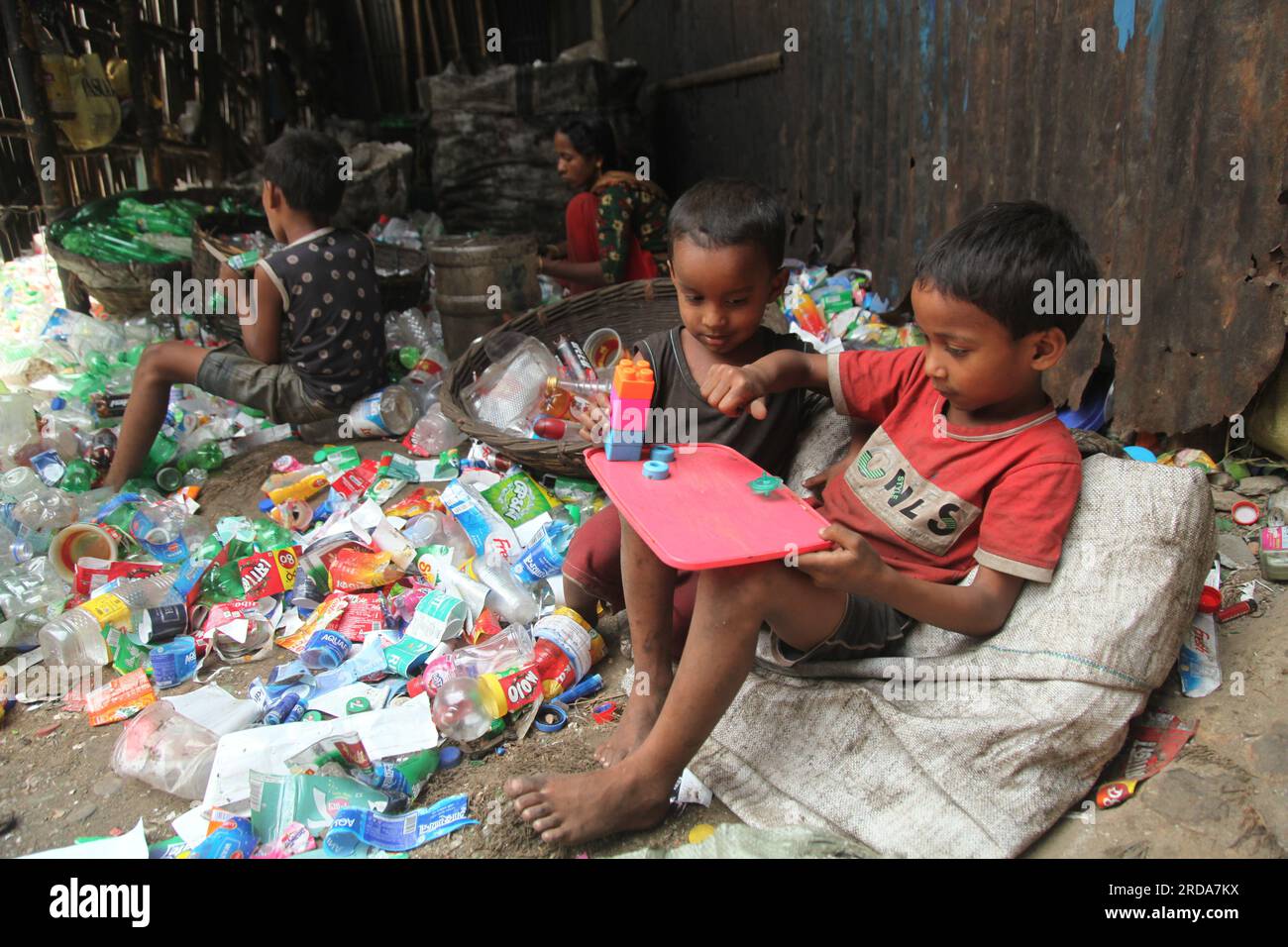 Dhaka, Dhaka, Bangladesh. 18 marzo 2023. I bambini giocano in una fabbrica di riciclaggio di bottiglie di plastica. è stata scattata una foto di kmarangichar beribadgh. Nazmul i Foto Stock