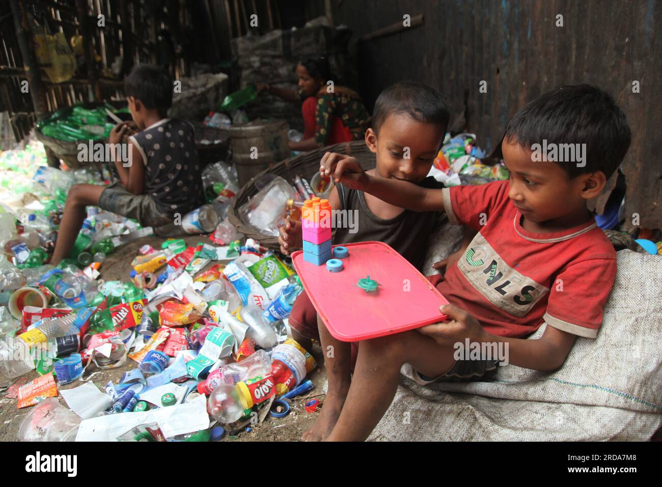 Dhaka, Dhaka, Bangladesh. 18 marzo 2023. I bambini giocano in una fabbrica di riciclaggio di bottiglie di plastica. è stata scattata una foto di kmarangichar beribadgh. Nazmul i Foto Stock