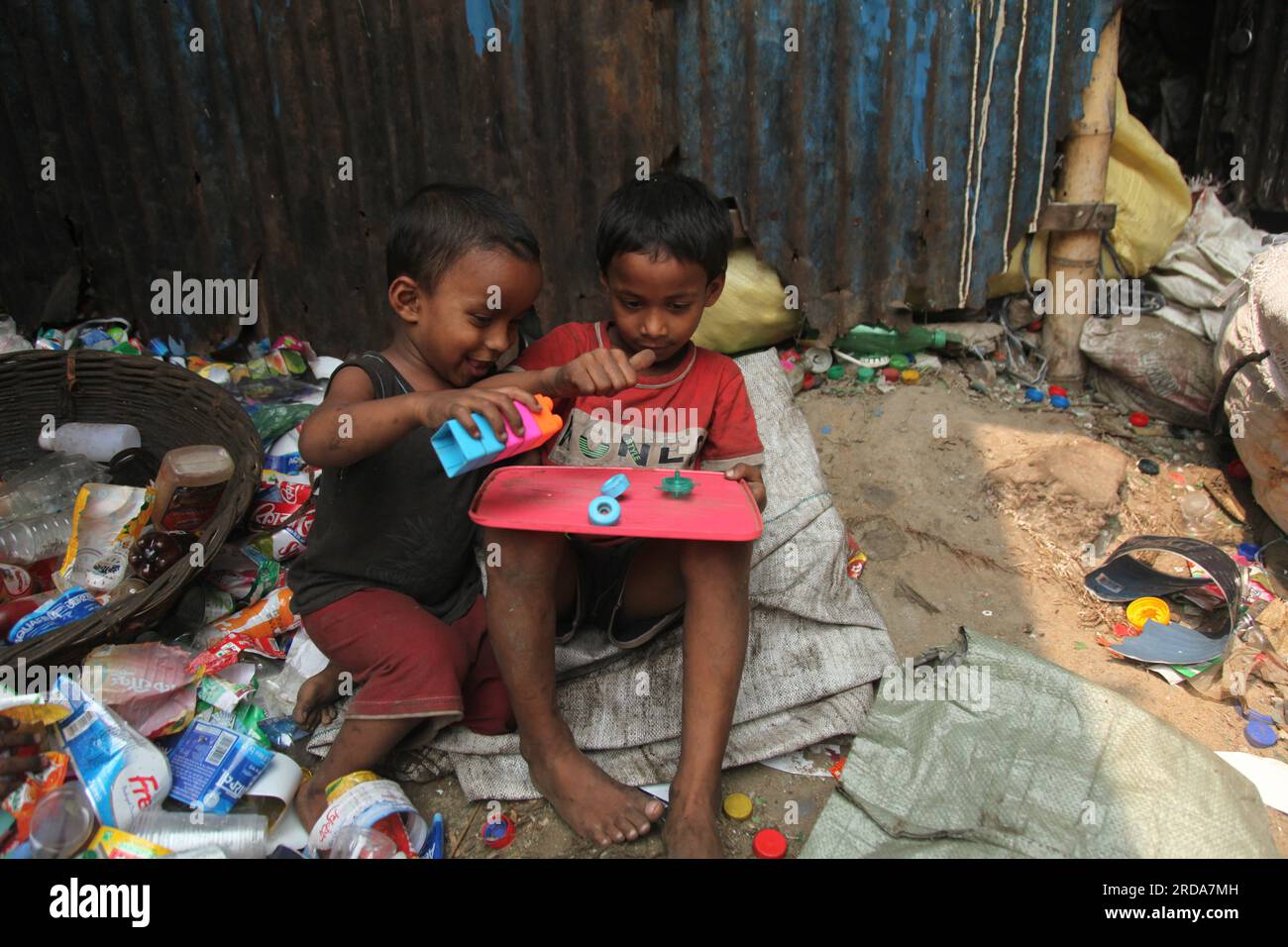 Dhaka, Dhaka, Bangladesh. 18 marzo 2023. I bambini giocano in una fabbrica di riciclaggio di bottiglie di plastica. è stata scattata una foto di kmarangichar beribadgh. Nazmul i Foto Stock