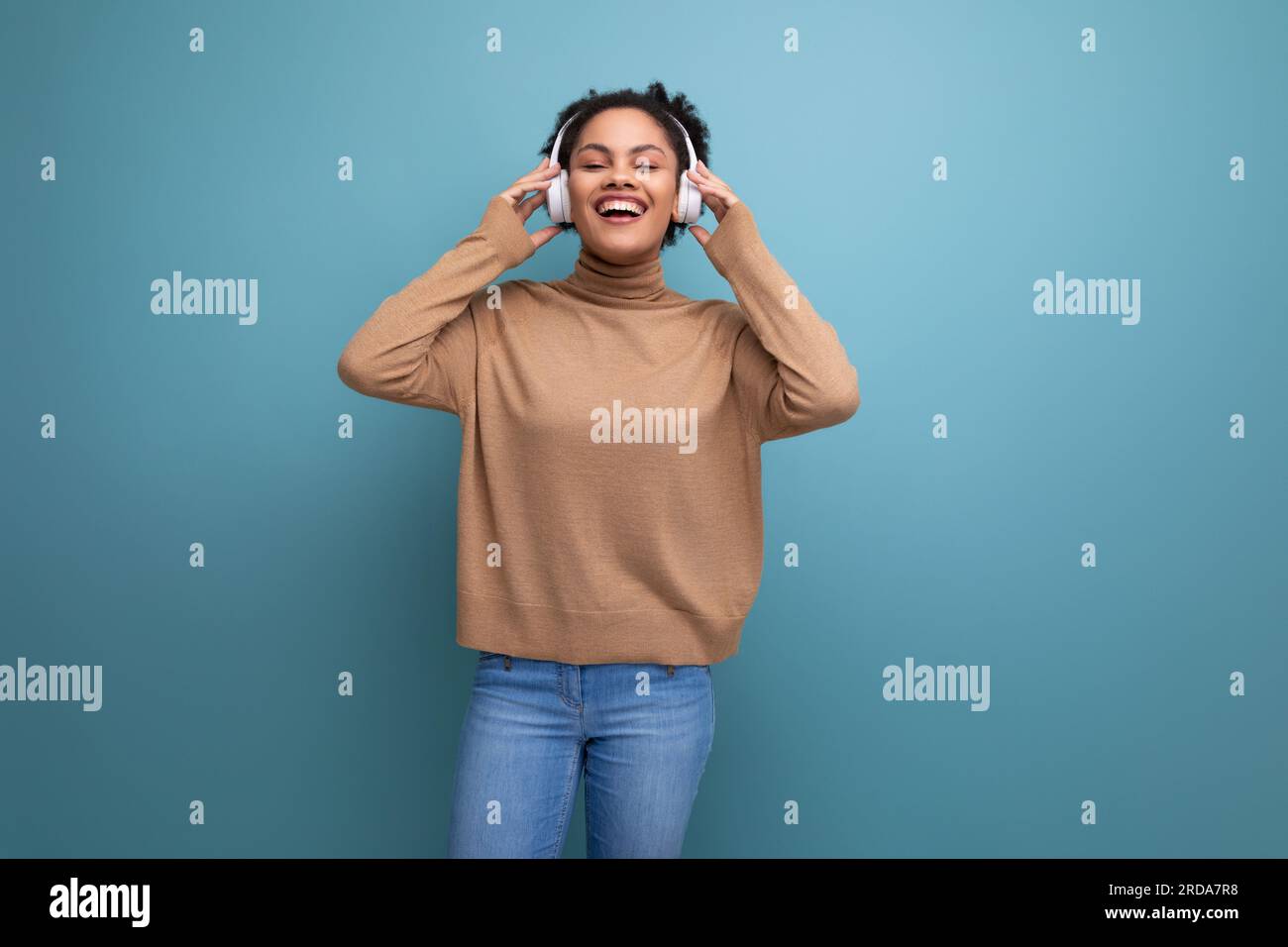 sfondo isolato, giovane bruna, freelance ispanica che ascolta musica con le cuffie bluetooth Foto Stock