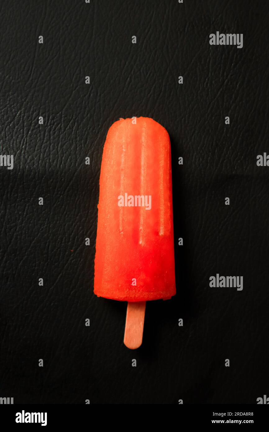 gelato su un bastoncino su sfondo nero, primo piano Foto Stock