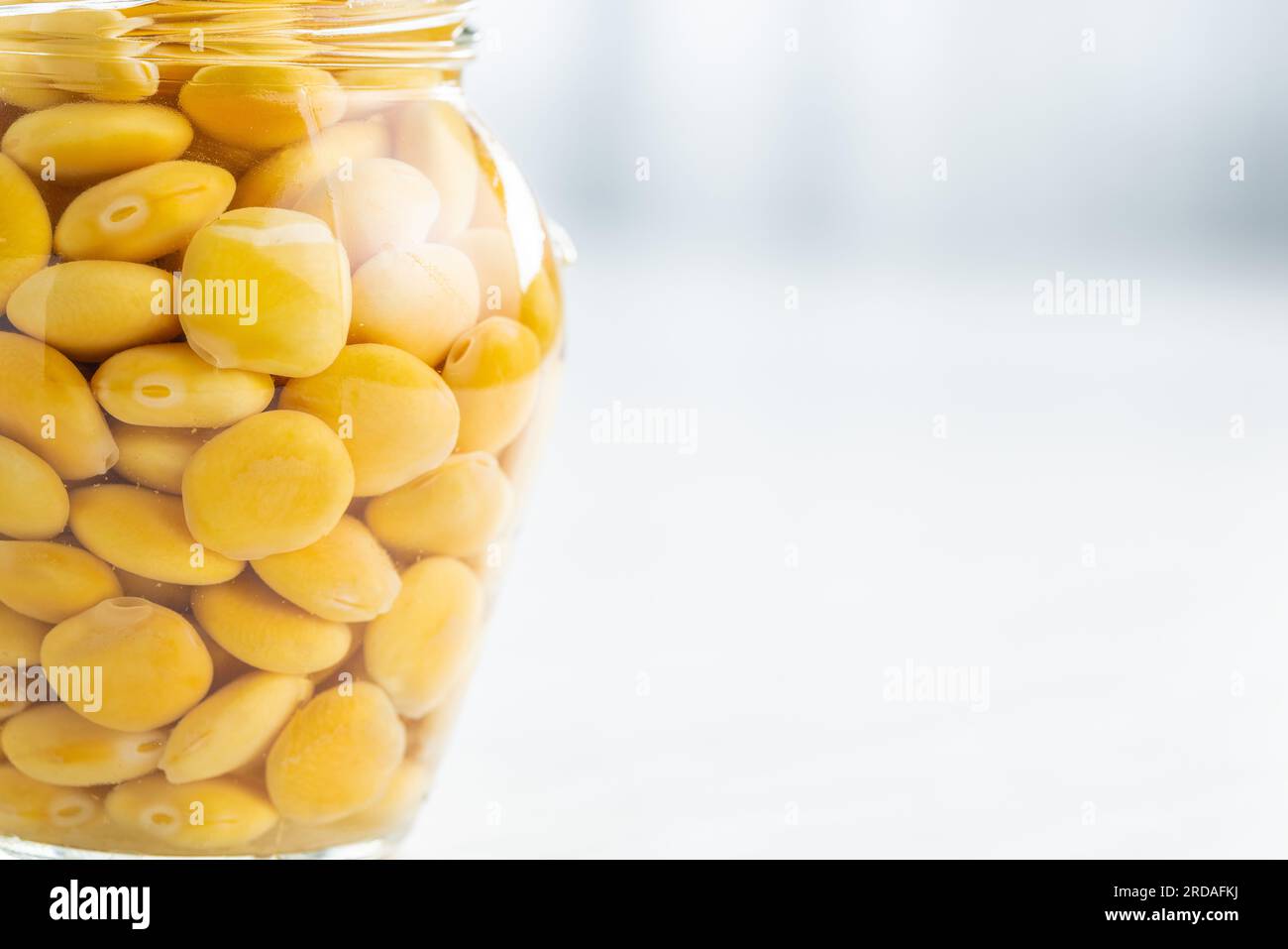 Fagioli Lupini in salamoia. Lupino sottaceto in barattolo sul tavolo della cucina. Foto Stock