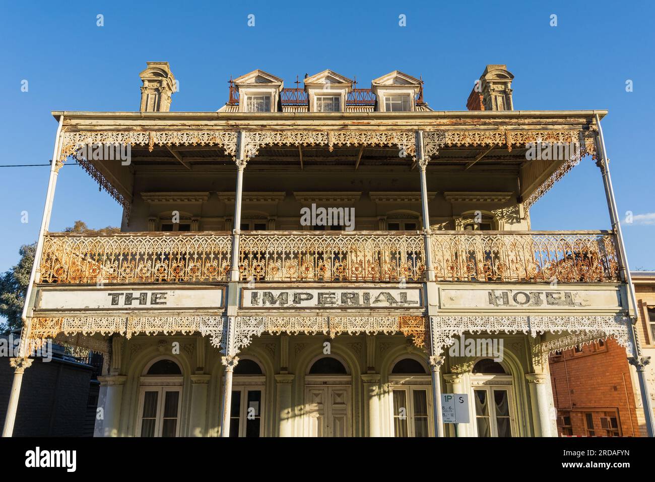 Streetscape presenta uno storico hotel a due piani con ferro battuto decorativo a Castlemaine nel centro di Victoria, Australia Foto Stock