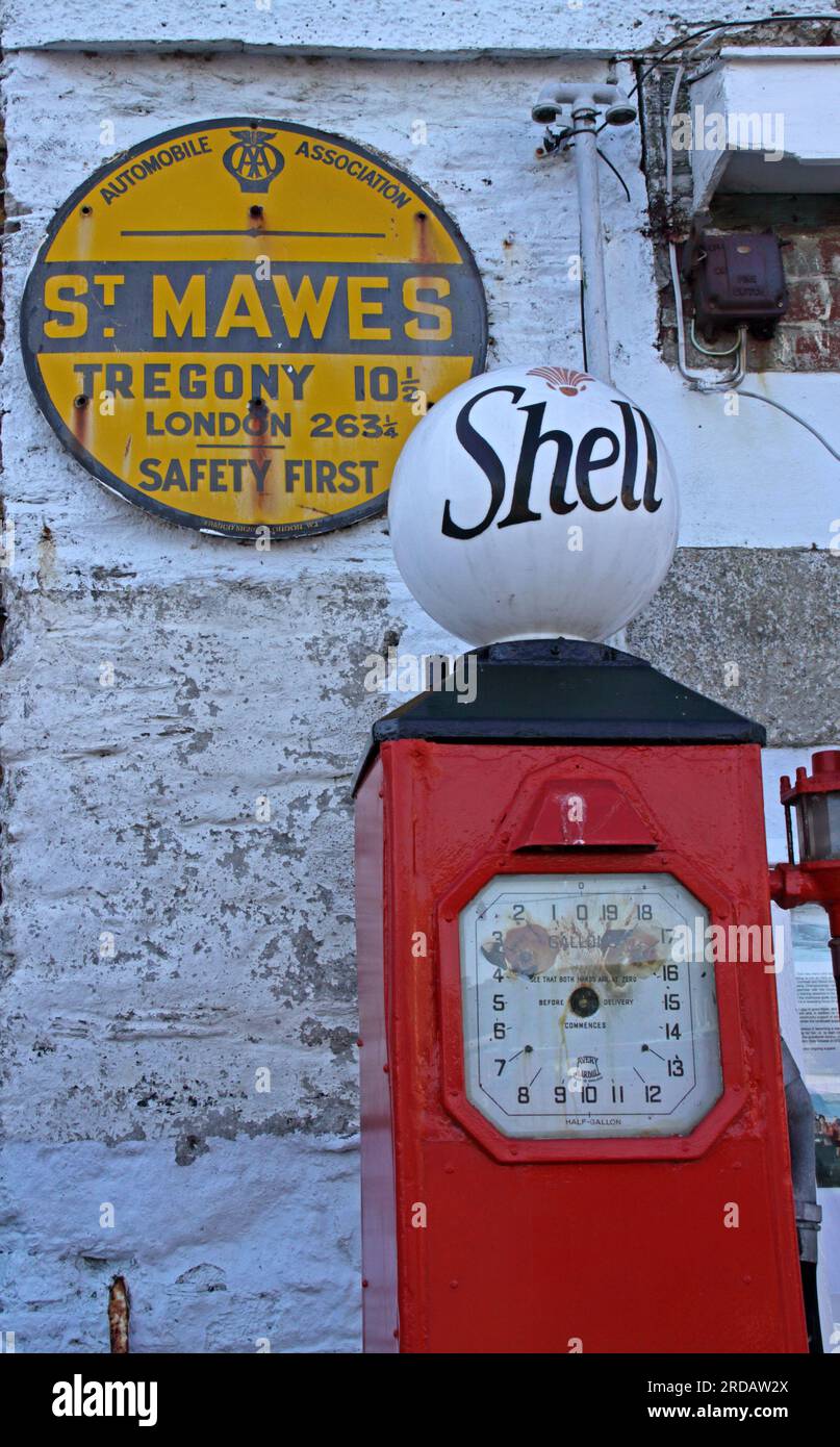 Pompa di benzina Shell d'epoca e cartello AA, verniciato di rosso sul lungomare, St Mawes, Cornovaglia, Inghilterra, Regno Unito, TR2 5AG Foto Stock