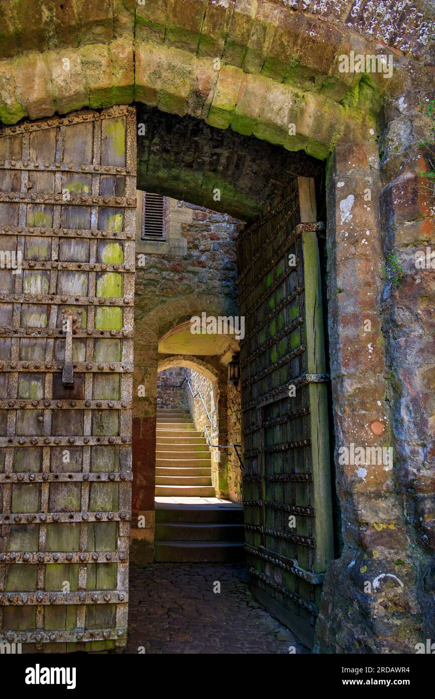 La storica porta di legno originale del XIII secolo e la scala in pietra nella Great Gatehouse a Dunster Castle, Somerset, Inghilterra, Regno Unito Foto Stock