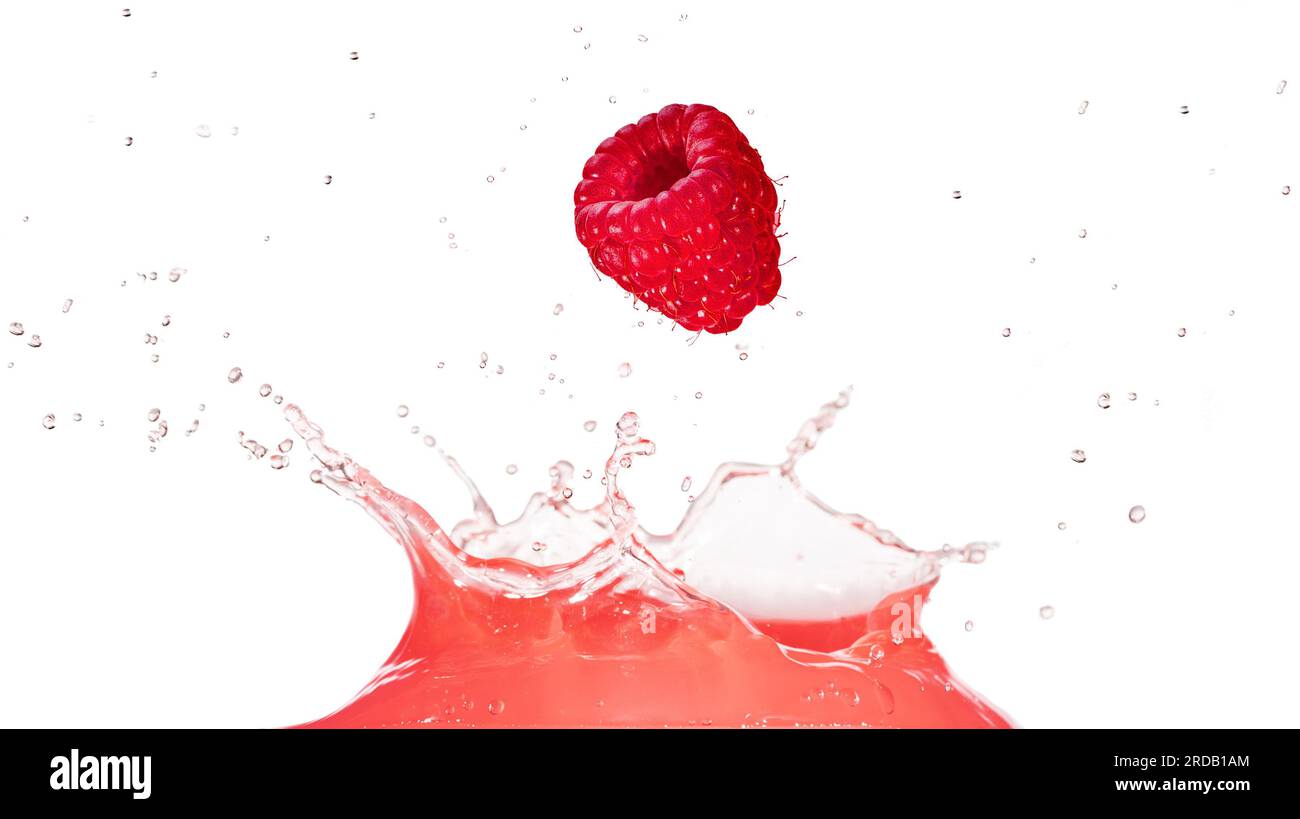 Lampone maturo che cade in un liquido rosa spruzzo di succo isolato su sfondo bianco. Colpo vero. Foto Stock