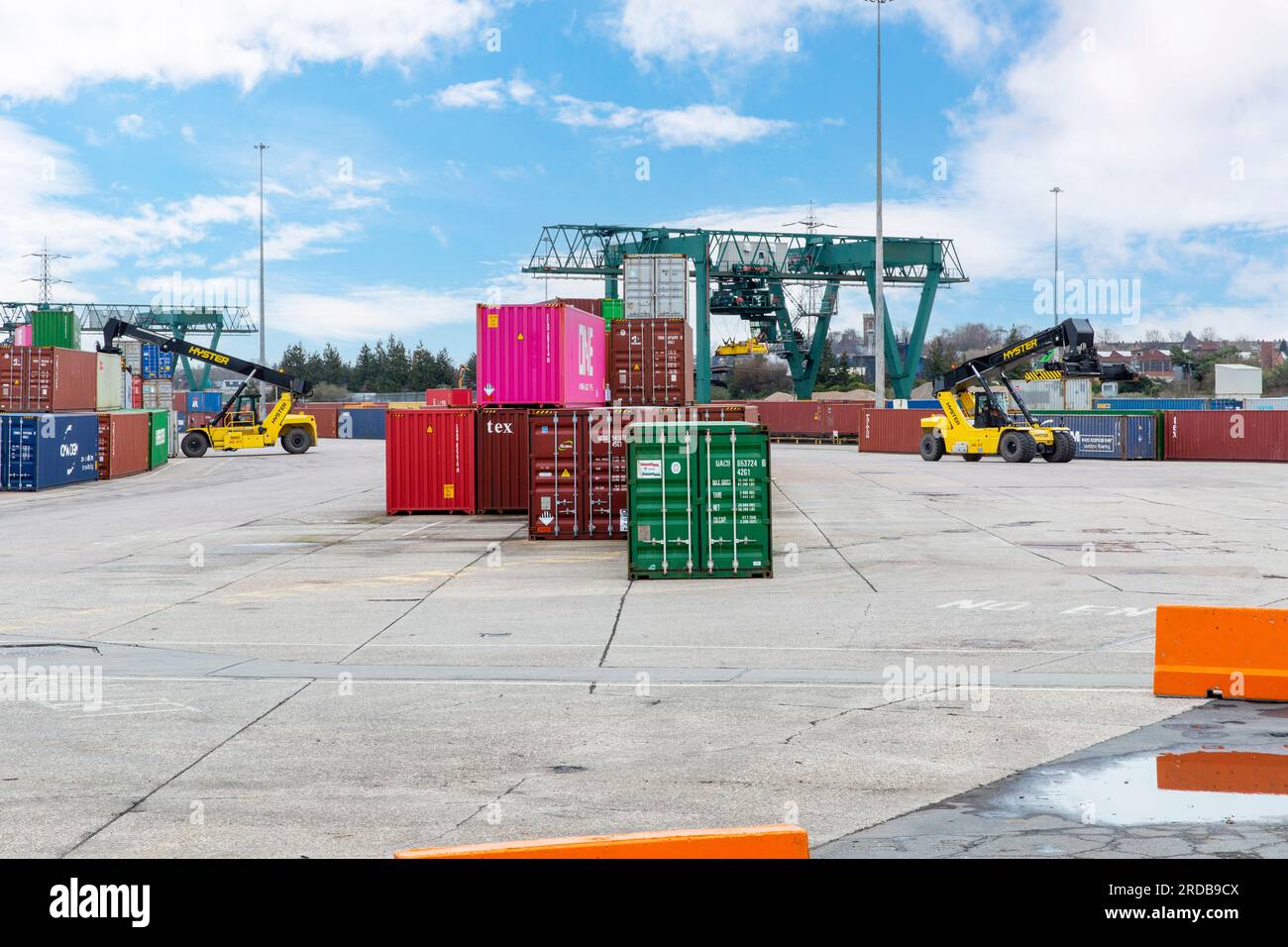 Un veicolo con caricatore dall'alto si sposta e accumula container per spedizioni intermodali presso un ICD (Inland Container Depot) in Inghilterra. Foto Stock
